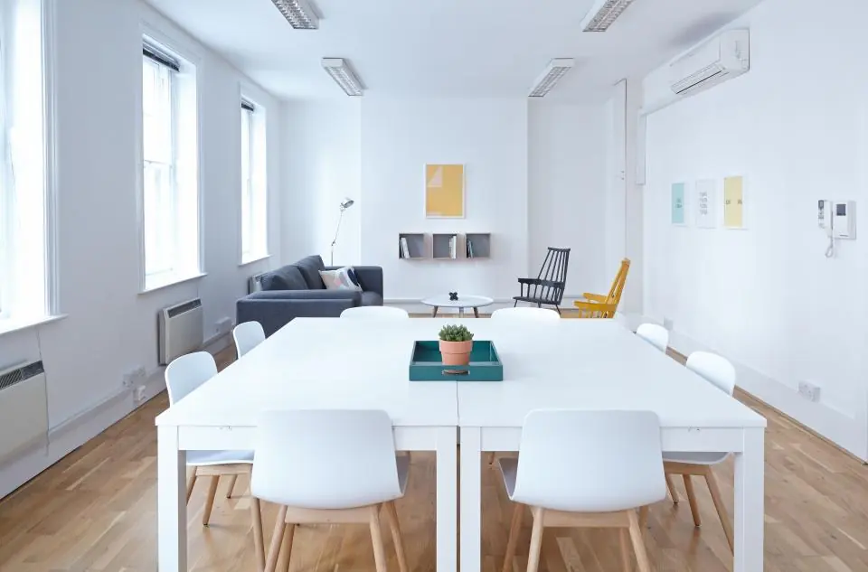 Salle de réunion lumineuse avec grande table blanche