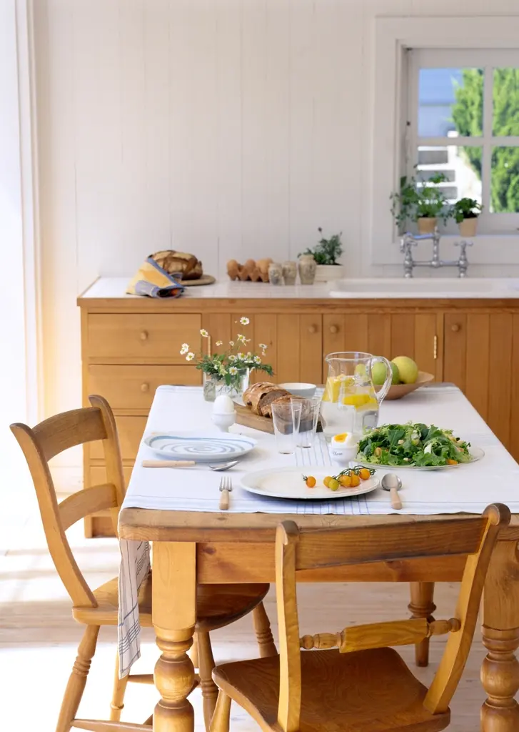 Table en bois massif dressée dans une cuisine lumineuse