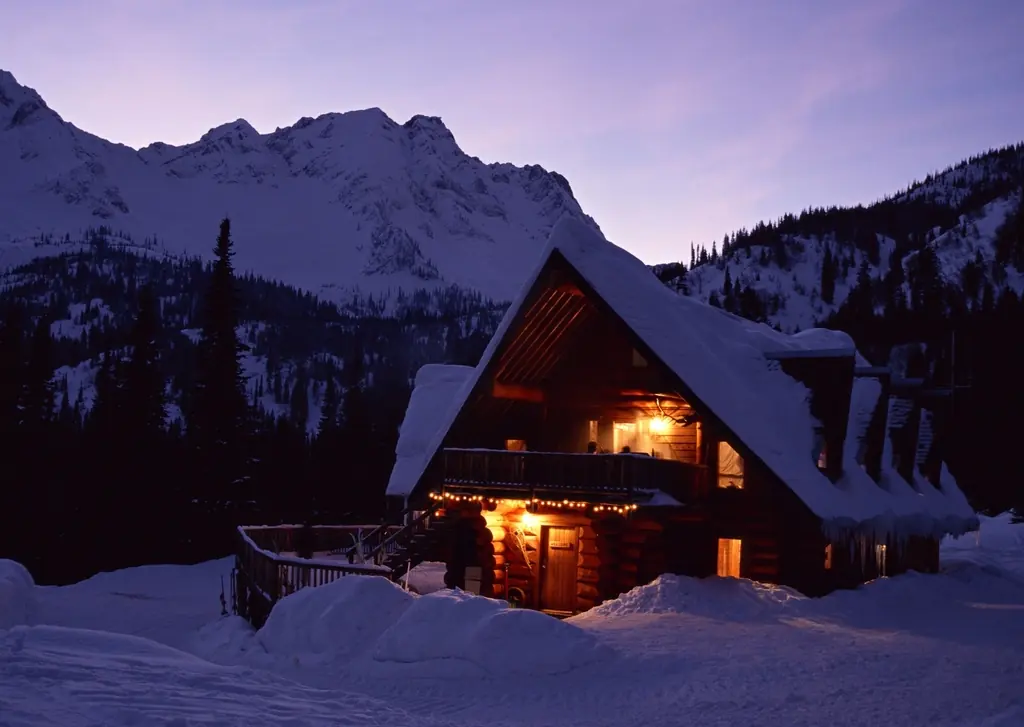 Chalet éclairé au crépuscule dans la neige