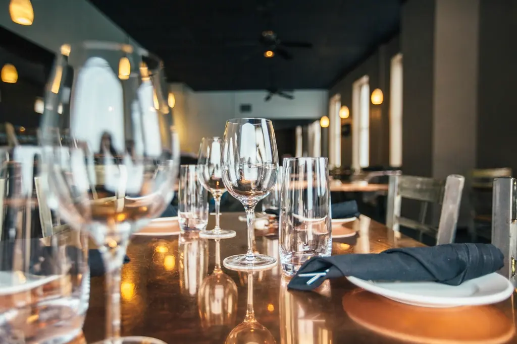 Salle de la brasserie dressée, verres à vin sur le comptoir