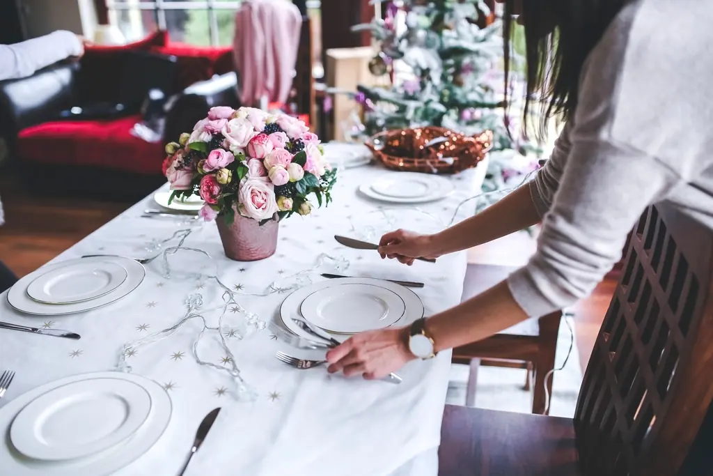 Serveuse dressant une table fleurie